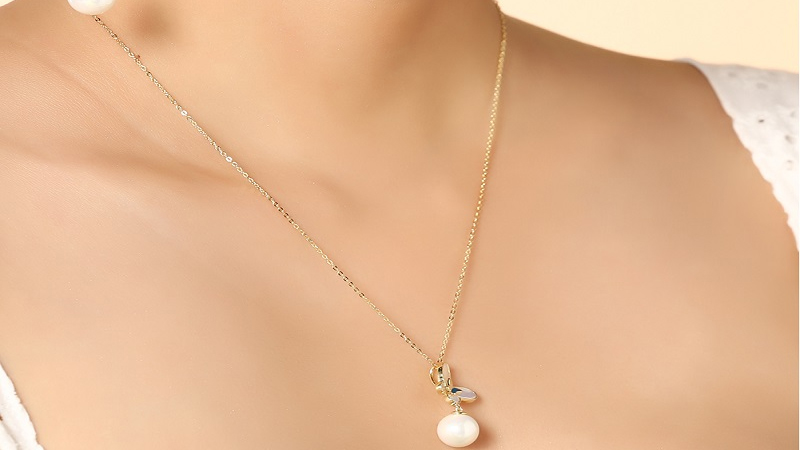 Mặt d&acirc;y chuyền l&agrave; một b&ocirc;ng hoa b&ecirc;n dưới l&agrave; một hạt ngọc trai